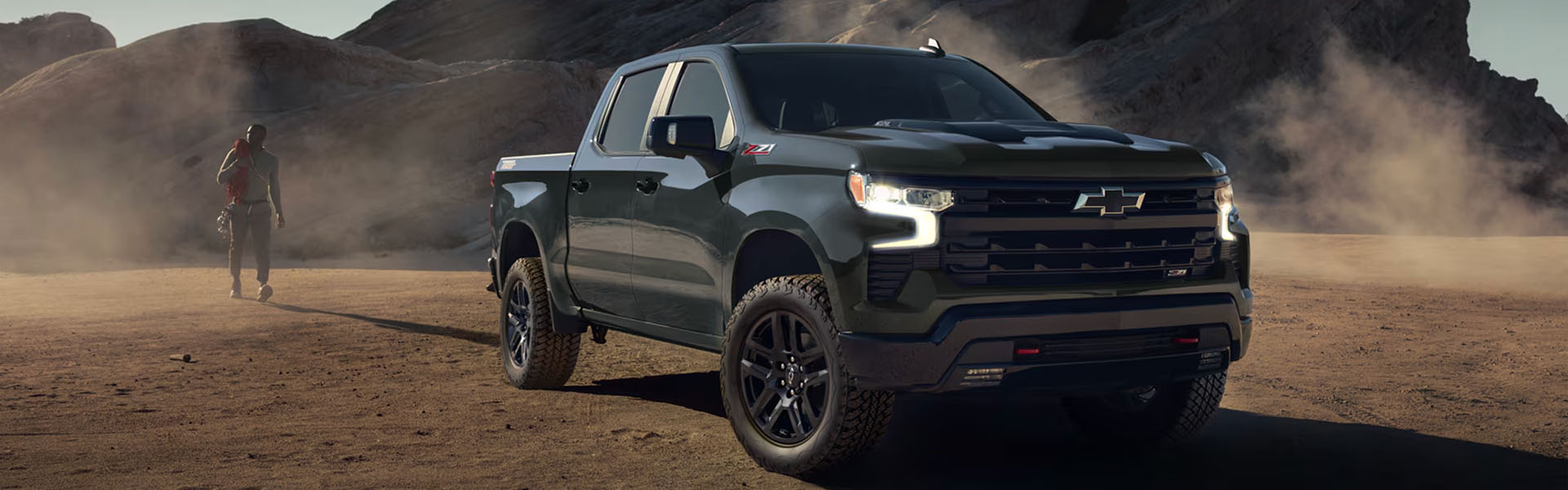 2026 Chevrolet Silverado 1500 Z71 4x4 pickup in green, showcasing rugged off-road capability, all-terrain tires, and bold front fascia in desert landscape